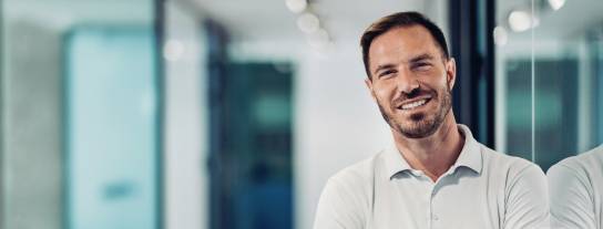 Mann lächelt mit verschränkten Armen